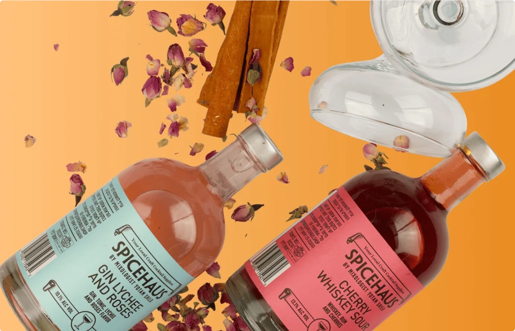 Two bottles of Spicehaus cocktails, "Gin Lychee and Roses" and "Cherry Whiskey Sour," displayed with cinnamon sticks, rose petals, and cocktail glasses on an orange background.