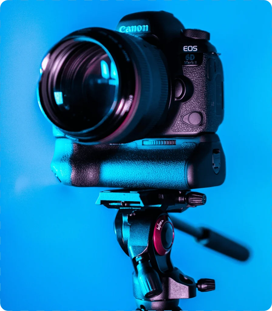 Canon EOS 6D Mark II DSLR camera on a tripod against a blue background