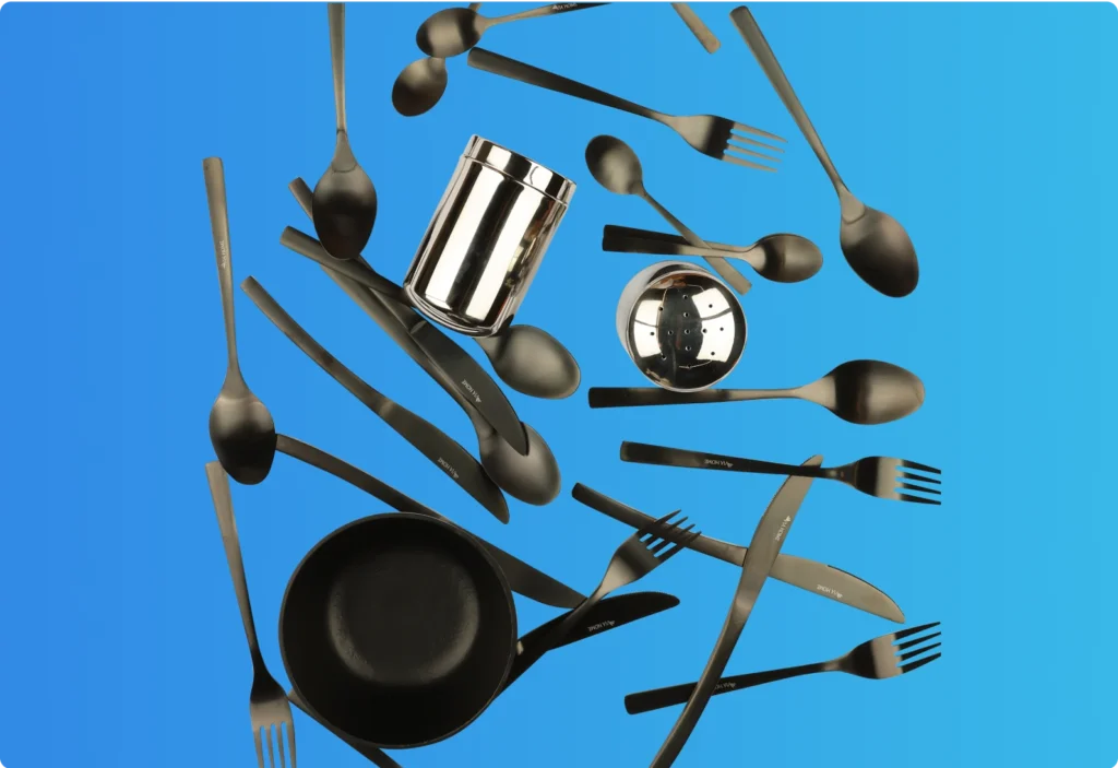 Assorted black cutlery set with forks, spoons, knives, and metallic containers displayed on a blue background